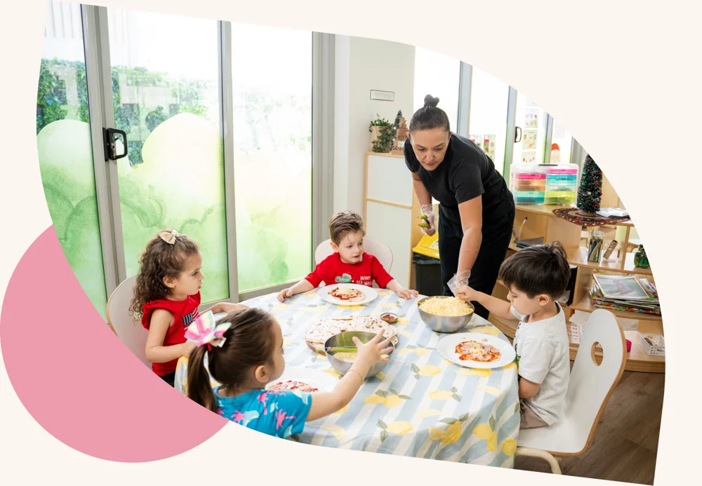 Children sharing a meal with an educator