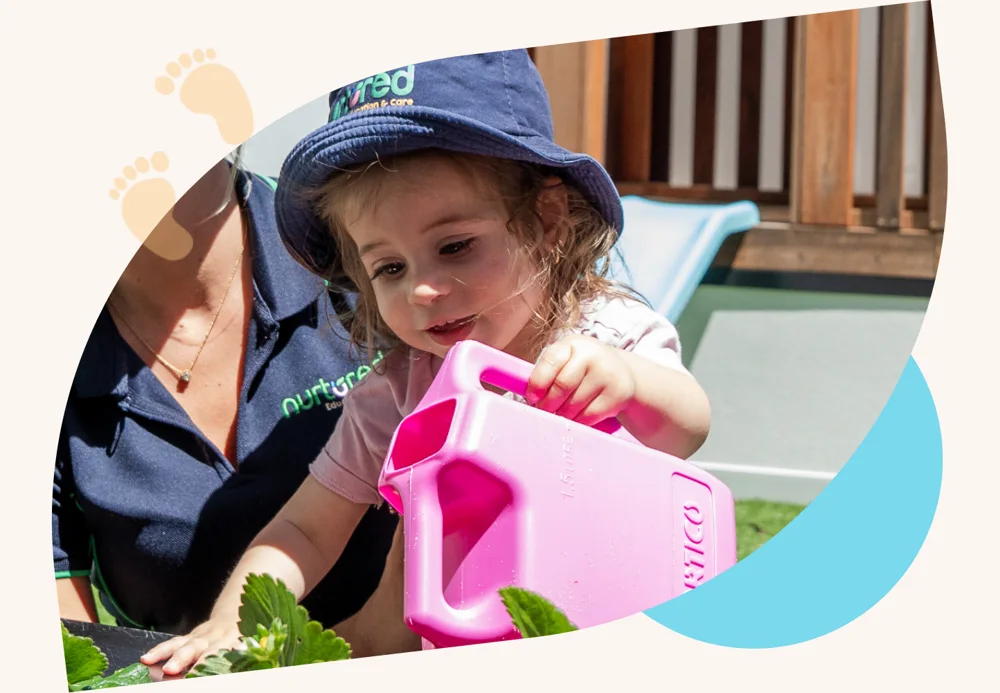 A child watering plants in the garden